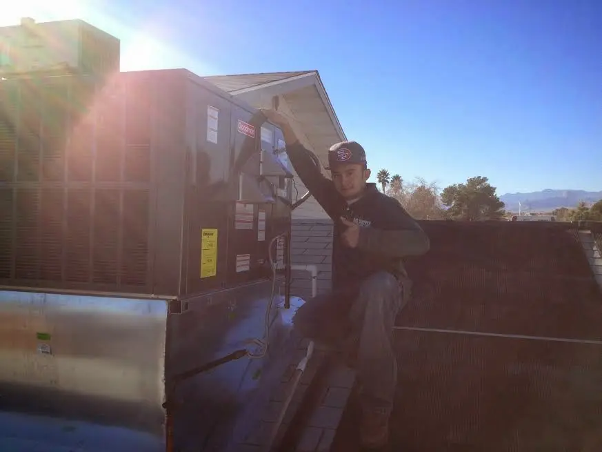 HVAC technician performing Air Duct Repair on a rooftop unit in Williamstown